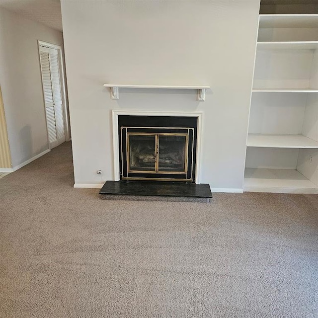 room details featuring a glass covered fireplace, carpet flooring, and baseboards