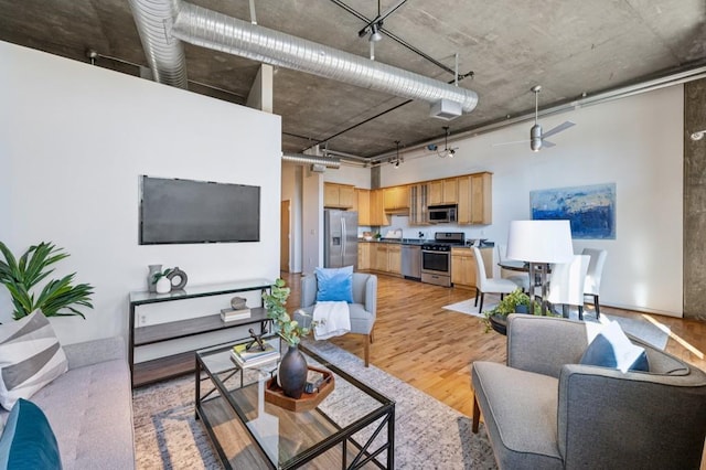 living room featuring ceiling fan and light hardwood / wood-style floors