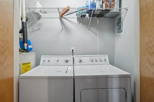 clothes washing area with water heater and independent washer and dryer