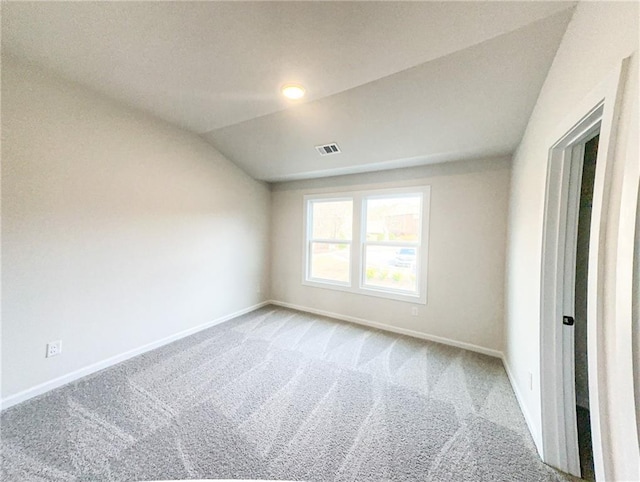 unfurnished room with light carpet and lofted ceiling