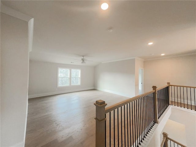 interior space with hardwood / wood-style flooring, ceiling fan, and crown molding