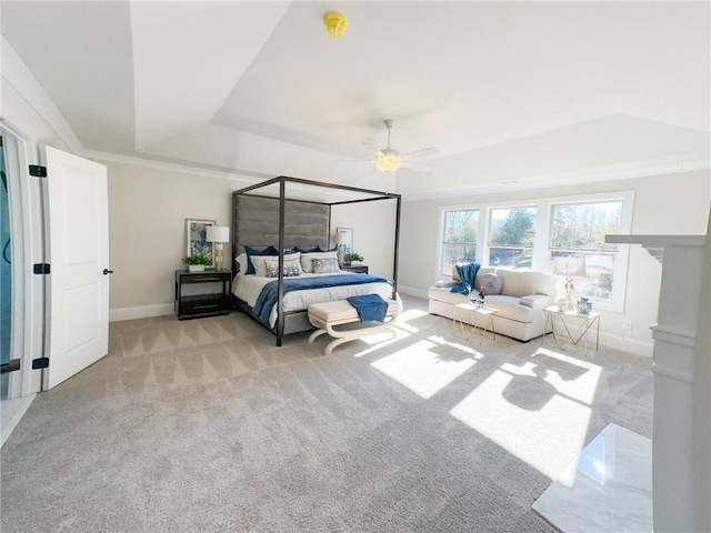 carpeted bedroom featuring a tray ceiling and ceiling fan