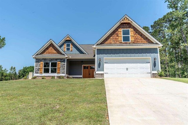 craftsman inspired home with a front lawn and a garage