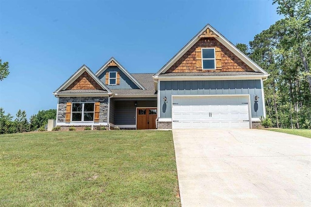 craftsman-style house featuring board and batten siding, a front lawn, driveway, and an attached garage