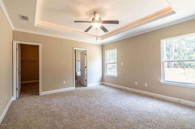 unfurnished bedroom featuring baseboards, visible vents, and a raised ceiling