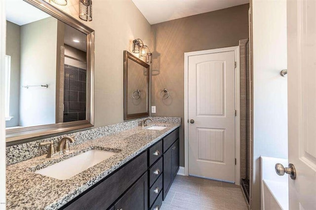 bathroom with a washtub, tile patterned floors, a sink, and double vanity