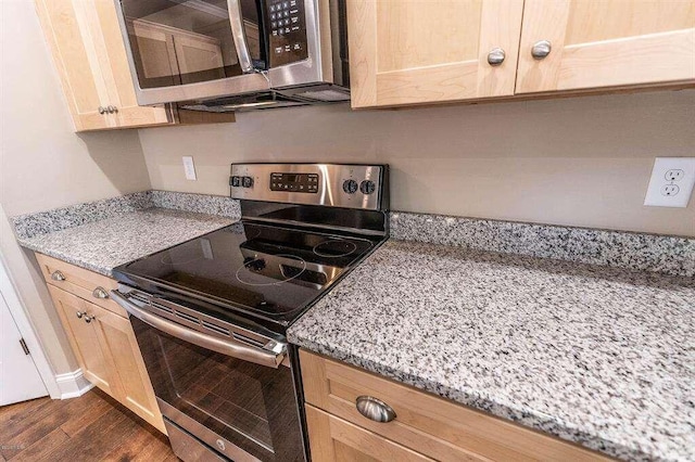 kitchen with light stone countertops, appliances with stainless steel finishes, dark wood-style flooring, and light brown cabinetry