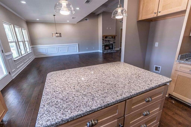 kitchen with dark wood-style floors, a fireplace, light stone counters, and open floor plan