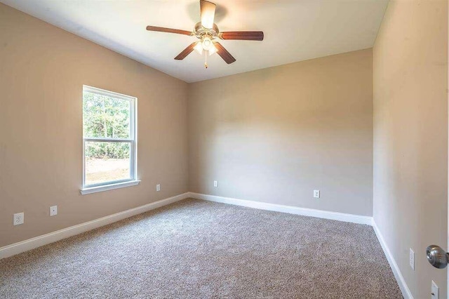 carpeted empty room with ceiling fan and baseboards