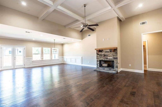 unfurnished living room with dark wood-style floors, a fireplace, coffered ceiling, and visible vents