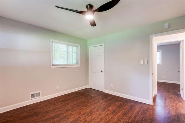 1401 Pine Ave, East Point, GA 30344 - unfurnished bedroom with multiple windows, dark wood finished floors, and ceiling fan