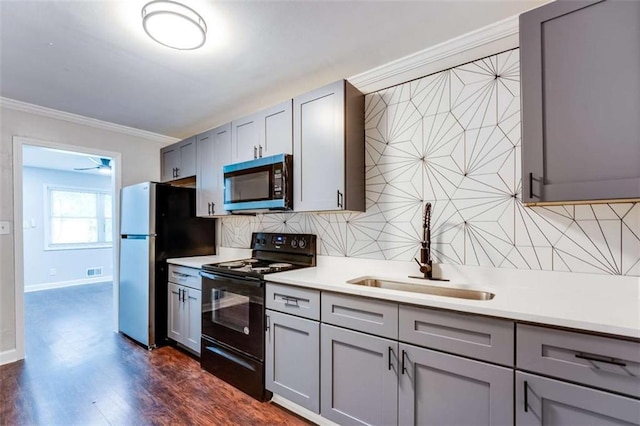 1401 Pine Ave, East Point, GA 30344 - kitchen with black range with electric stovetop, gray cabinets, freestanding refrigerator, tasteful backsplash, and light countertops