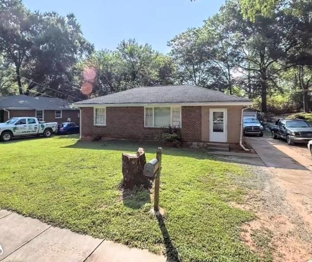 single story home featuring a front yard and brick siding