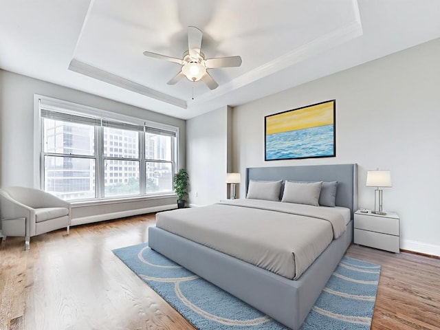3334 Peachtree Rd NE Unit 614, Atlanta, GA 30326 - bedroom featuring a raised ceiling, wood finished floors, ceiling fan, and crown molding