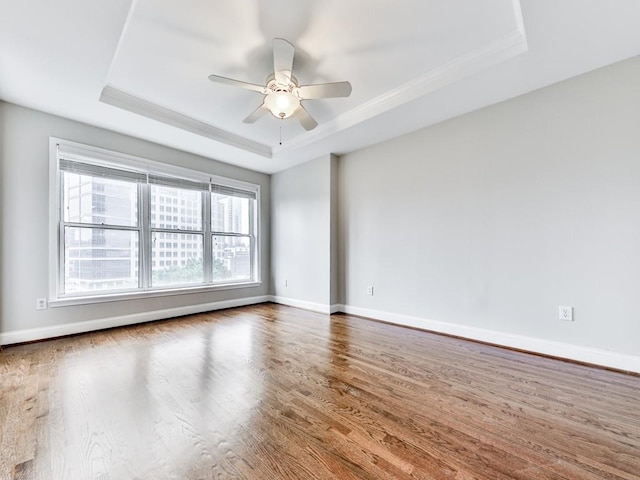 3334 Peachtree Rd NE Unit 614, Atlanta, GA 30326 - spare room with a tray ceiling, healthy amount of natural light, wood finished floors, a ceiling fan, and crown molding