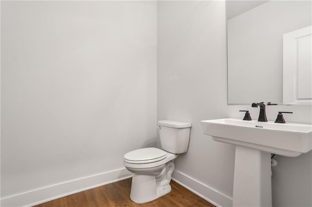 bathroom featuring hardwood / wood-style flooring and toilet