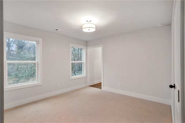 empty room with plenty of natural light and carpet