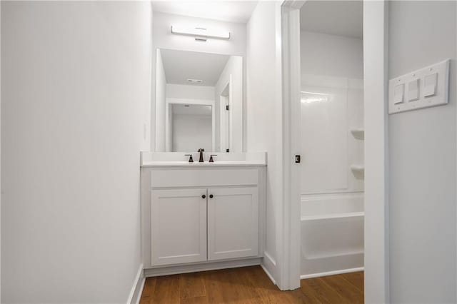 bathroom featuring shower / bath combination, vanity, and hardwood / wood-style floors