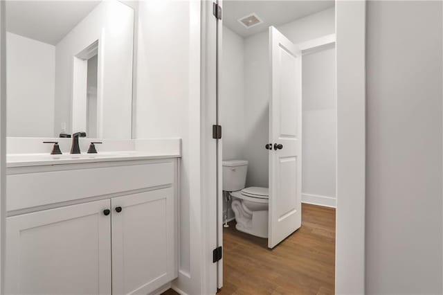 bathroom with vanity, hardwood / wood-style floors, and toilet