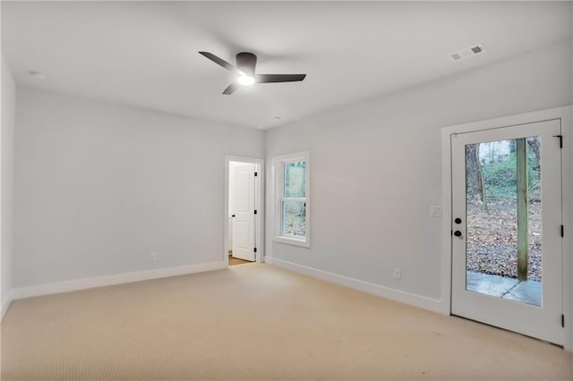 carpeted empty room featuring a wealth of natural light and ceiling fan