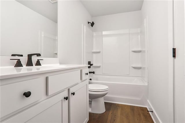 full bathroom featuring vanity, hardwood / wood-style flooring, toilet, and washtub / shower combination