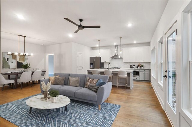 living room with dark wood-type flooring, an inviting chandelier, and sink