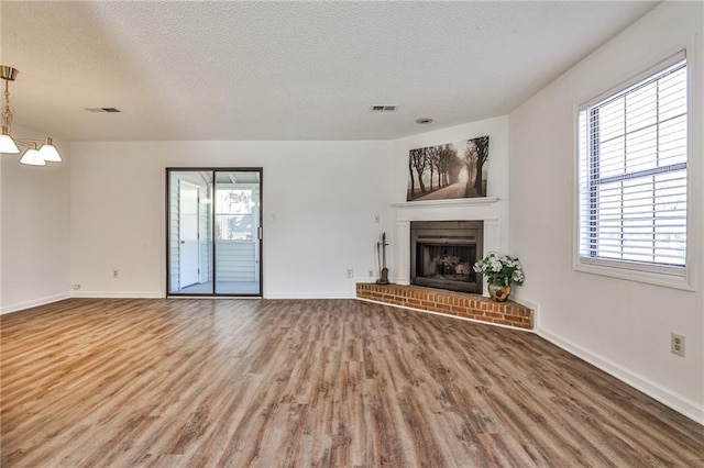 unfurnished living room featuring wood finished floors, visible vents, and a healthy amount of sunlight