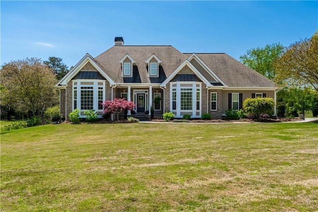 view of front of house featuring a chimney, a front lawn, and brick siding