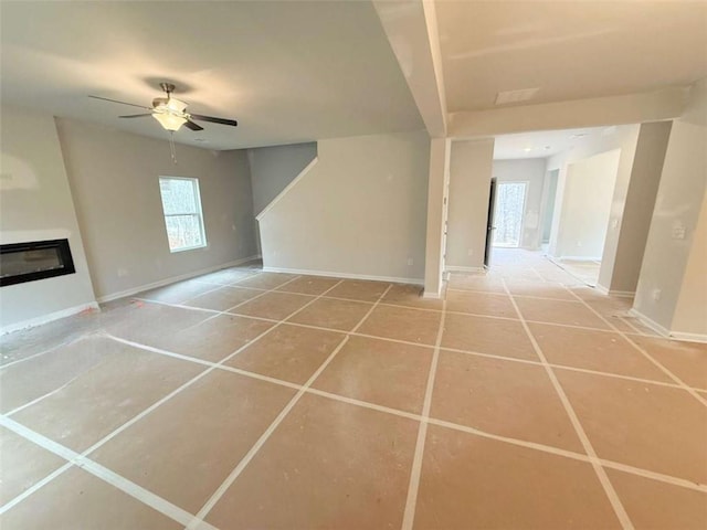 5518 Legacy Trl, Douglasville, GA 30135 - unfurnished living room with a ceiling fan, baseboards, a glass covered fireplace, and tile patterned flooring