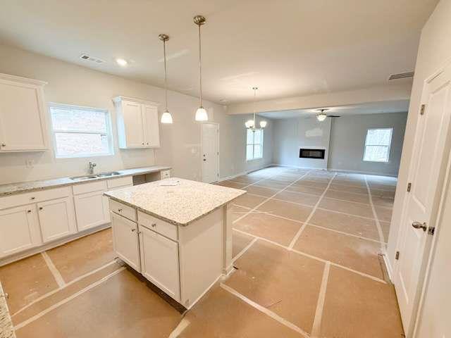 5518 Legacy Trl, Douglasville, GA 30135 - kitchen featuring a kitchen island, white cabinets, decorative light fixtures, open floor plan, and recessed lighting