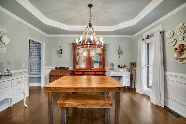 dining room featuring a notable chandelier, dark hardwood / wood-style flooring, crown molding, and a tray ceiling