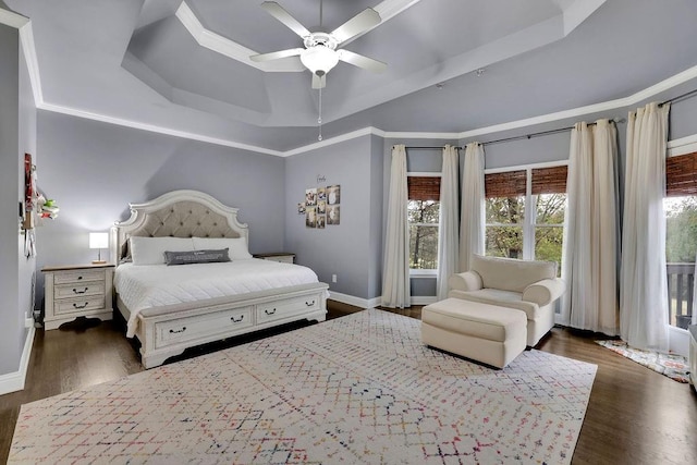 bedroom featuring ceiling fan, a raised ceiling, ornamental molding, and dark wood-type flooring