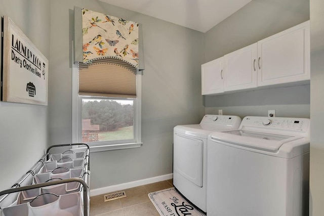 clothes washing area with cabinets, light tile patterned floors, and separate washer and dryer