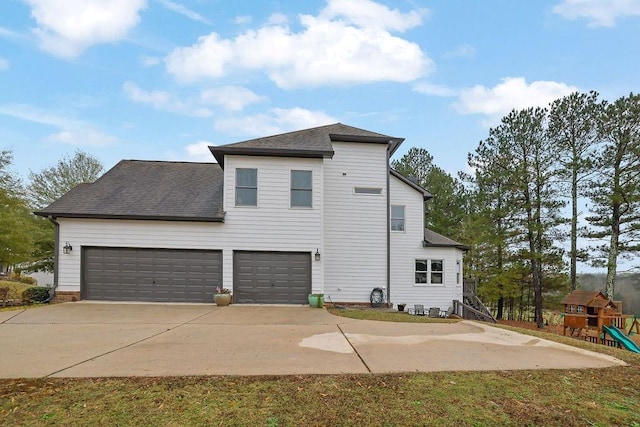 exterior space featuring a playground and a garage