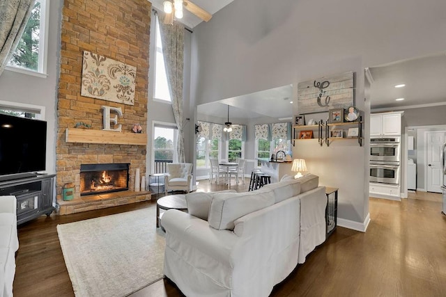 living room with dark hardwood / wood-style floors, ceiling fan, and a towering ceiling