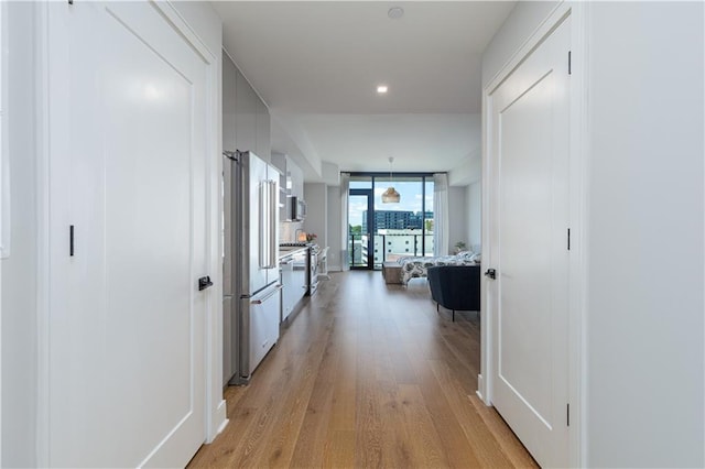 corridor featuring light hardwood / wood-style floors and a wall of windows