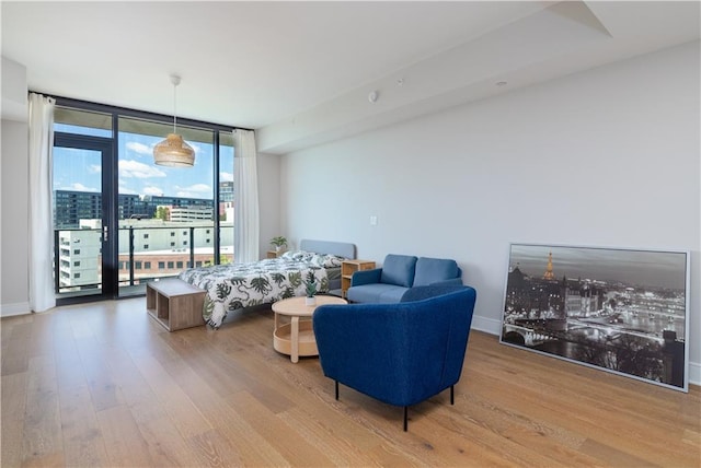 living room with hardwood / wood-style flooring and a wall of windows