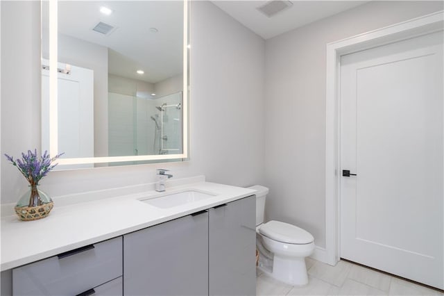 bathroom with tile patterned flooring, vanity, toilet, and a shower with door