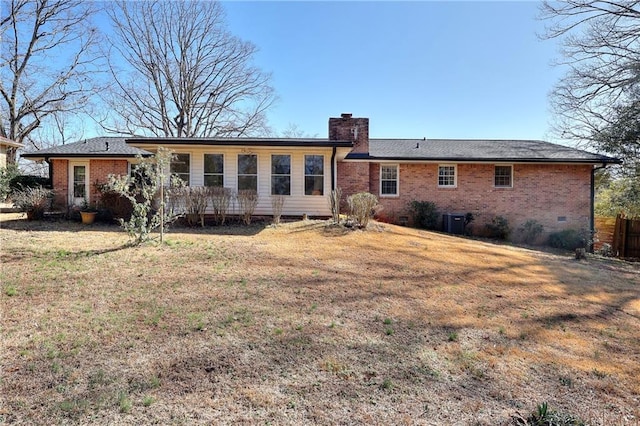 back of property featuring central AC and a lawn