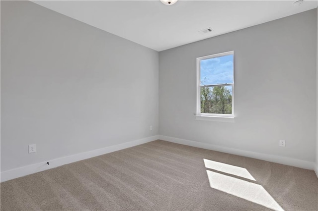 empty room with carpet flooring, baseboards, and visible vents