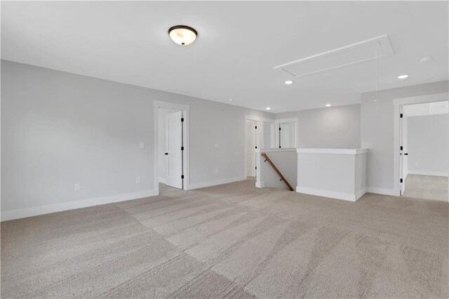 empty room with light carpet, attic access, baseboards, and recessed lighting