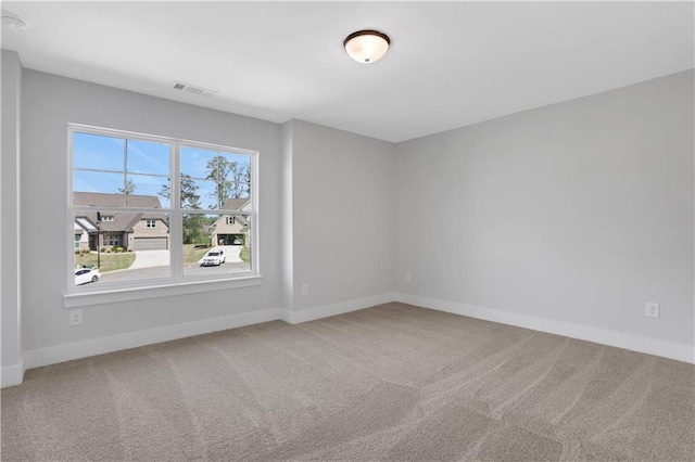 carpeted empty room with visible vents and baseboards