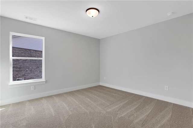 unfurnished room with visible vents, baseboards, and carpet