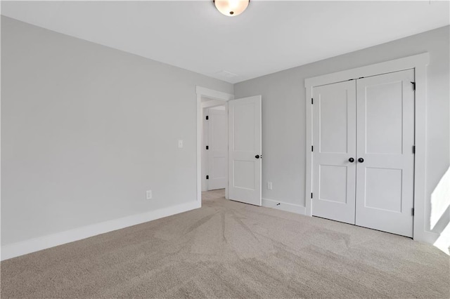 unfurnished bedroom featuring a closet, baseboards, and carpet floors