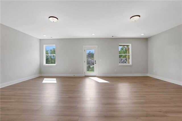 spare room featuring wood finished floors, baseboards, and recessed lighting