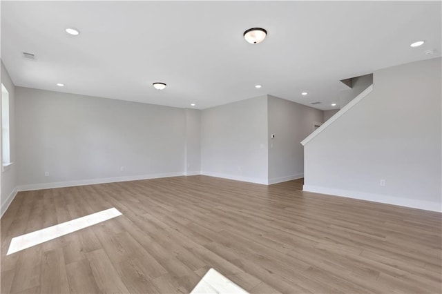 empty room featuring light wood-type flooring, baseboards, visible vents, and recessed lighting
