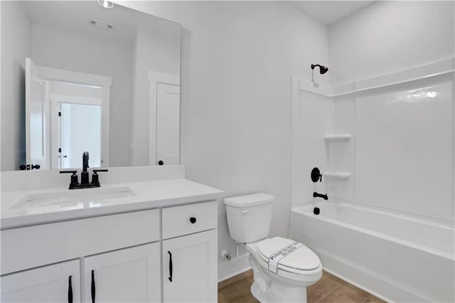 full bath featuring vanity, shower / bath combination, toilet, visible vents, and wood finished floors