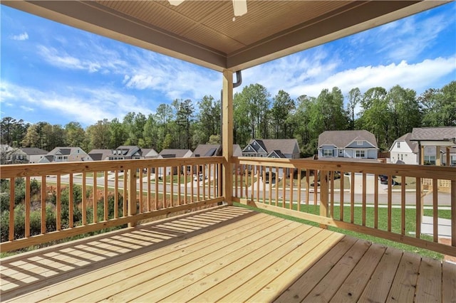 deck featuring a residential view, a lawn, and ceiling fan