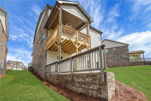back of house with a yard, central air condition unit, and a wooden deck