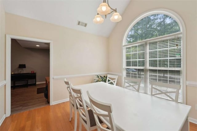 dining room with light wood-type flooring, lofted ceiling, and baseboards